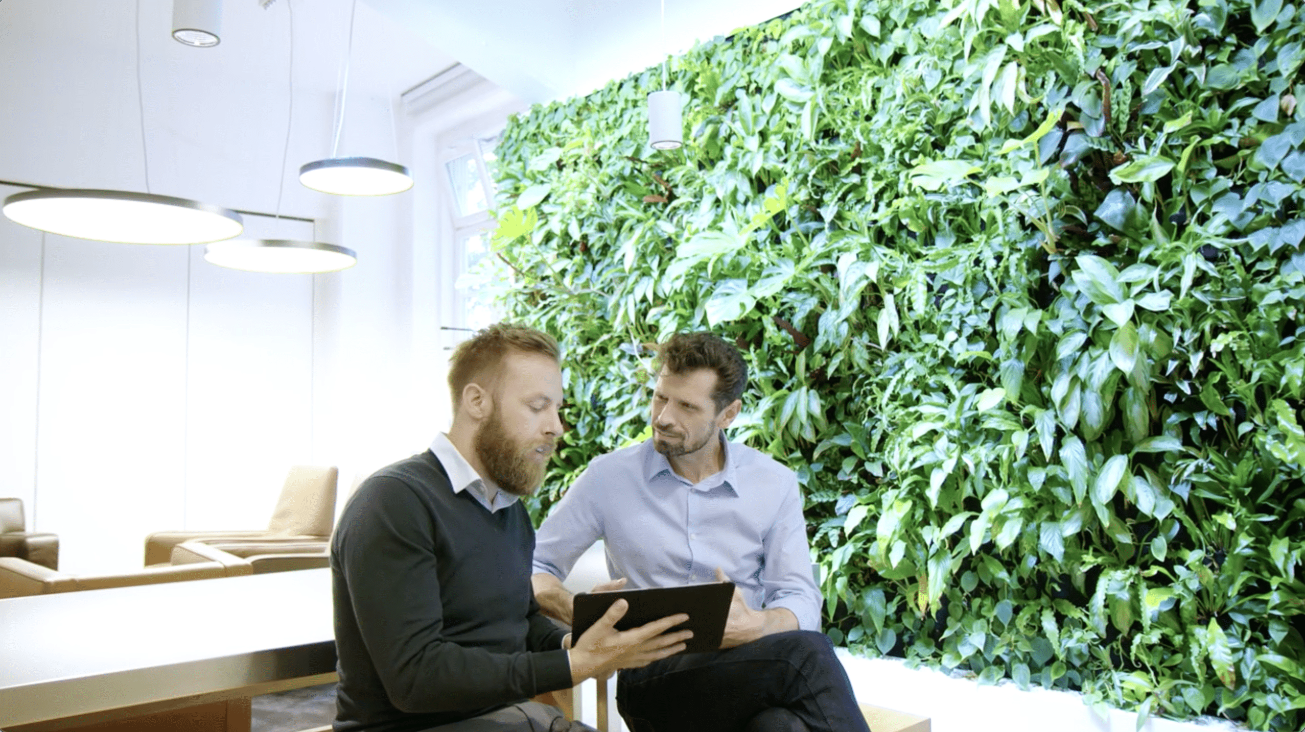 Two tech executives reviewing a business plan on a tablet.